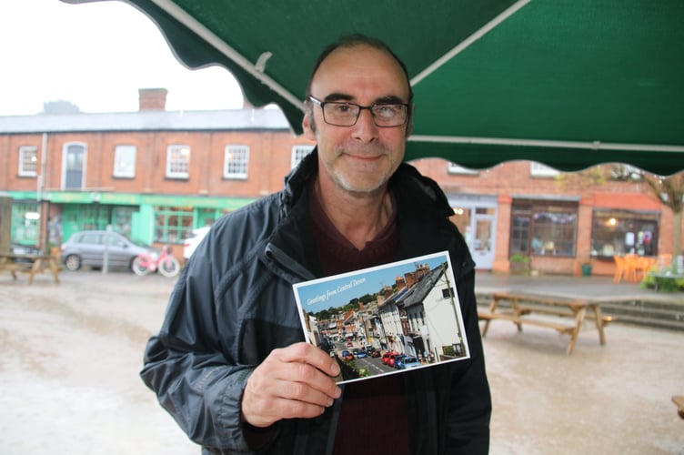 Michael Gurney, secretary of the Devon National Education Union with a copy of the postcard which the public was invited to take to send to Mel Stride MP.  AQ 0448