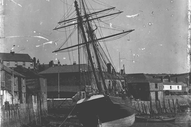 Salcombe ship 'Lord Devon' moored alongside at Salcombe, below Custom House Quay. Low tide, note children in boat.